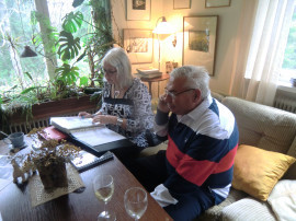 Birgitta Andersson tittar på bilder medan Ulf Oskarsson pratar i telefon med syster Karin Blomkvist, som tyvärr inte kunde vara med